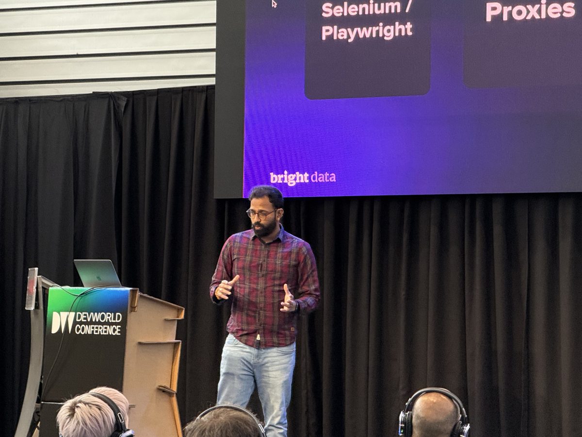 Anil mid-presentation, Bright Data logo on the stage screen